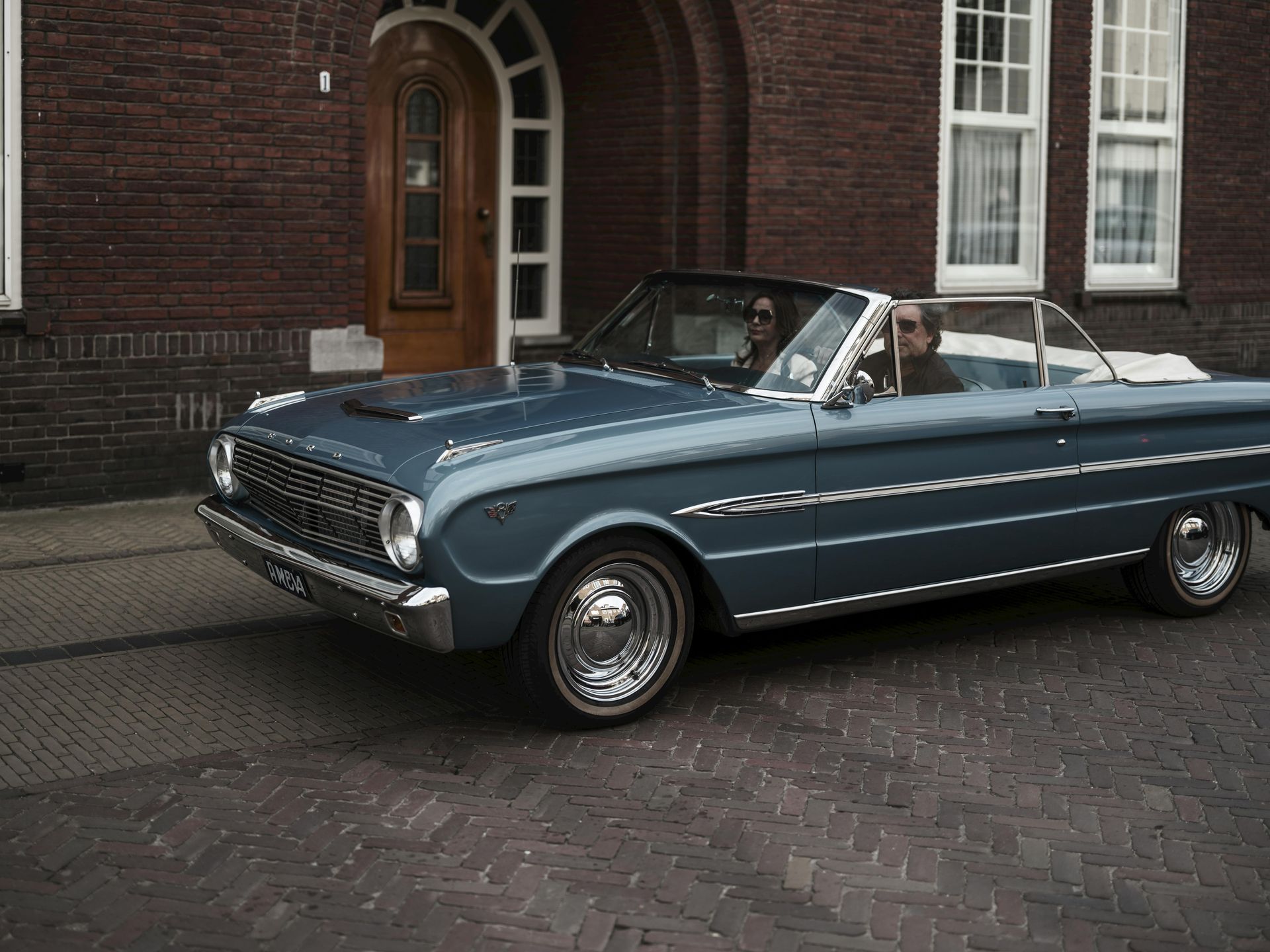 A woman is sitting at a table looking at her cell phone.