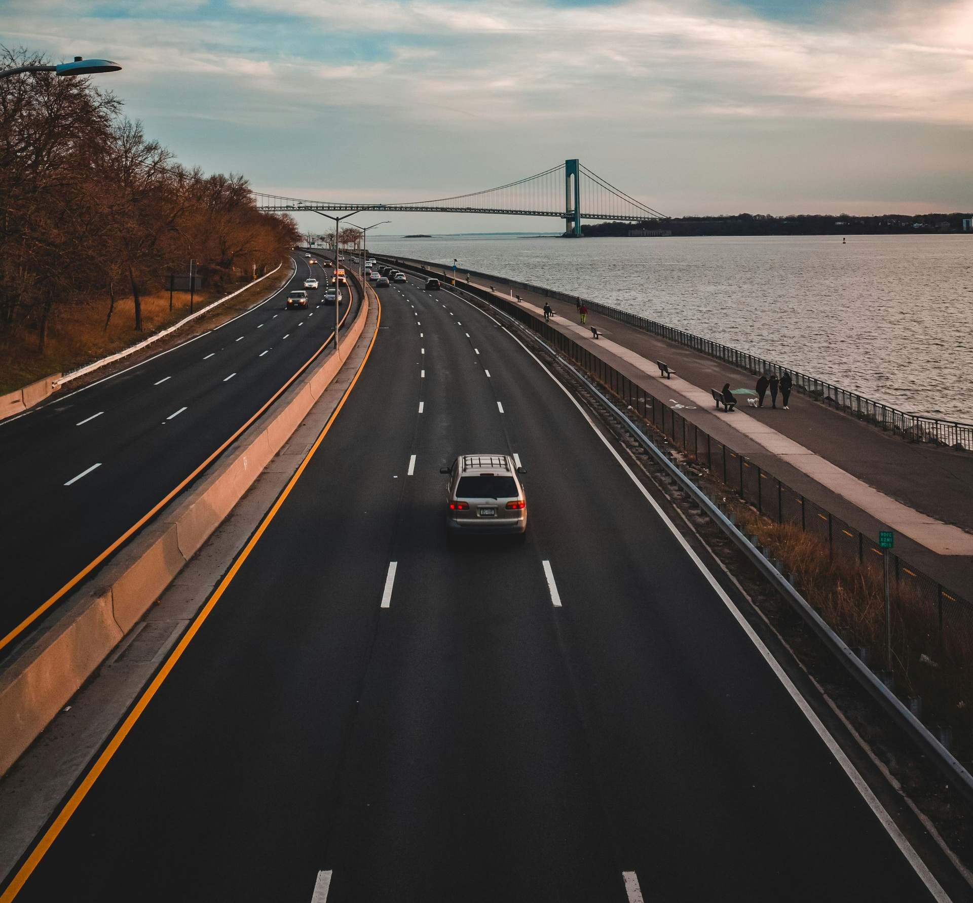 A woman is walking down the street holding a cup of coffee.