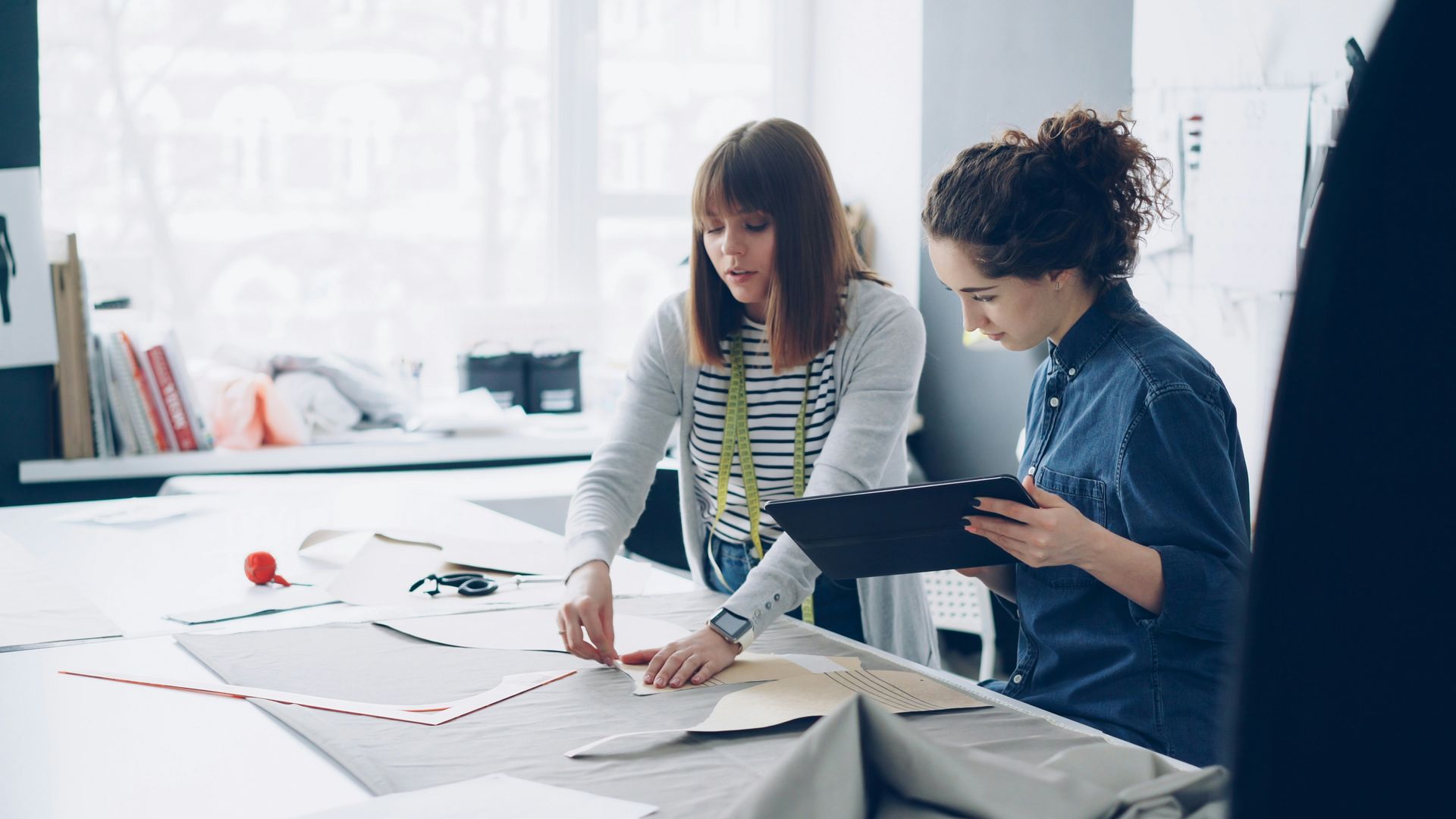 A woman is walking down the street holding a cup of coffee.