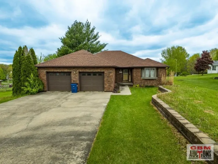 A brick house with two garage doors is for sale by odm auctions