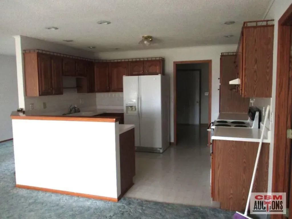 An empty kitchen with a sign that says cdm auctions