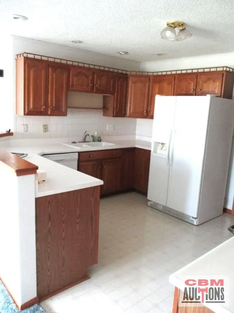 A kitchen with wooden cabinets and a white refrigerator
