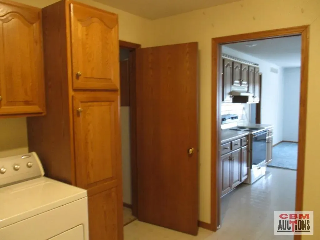 A laundry room with a washer and dryer and a sign that says com auctions