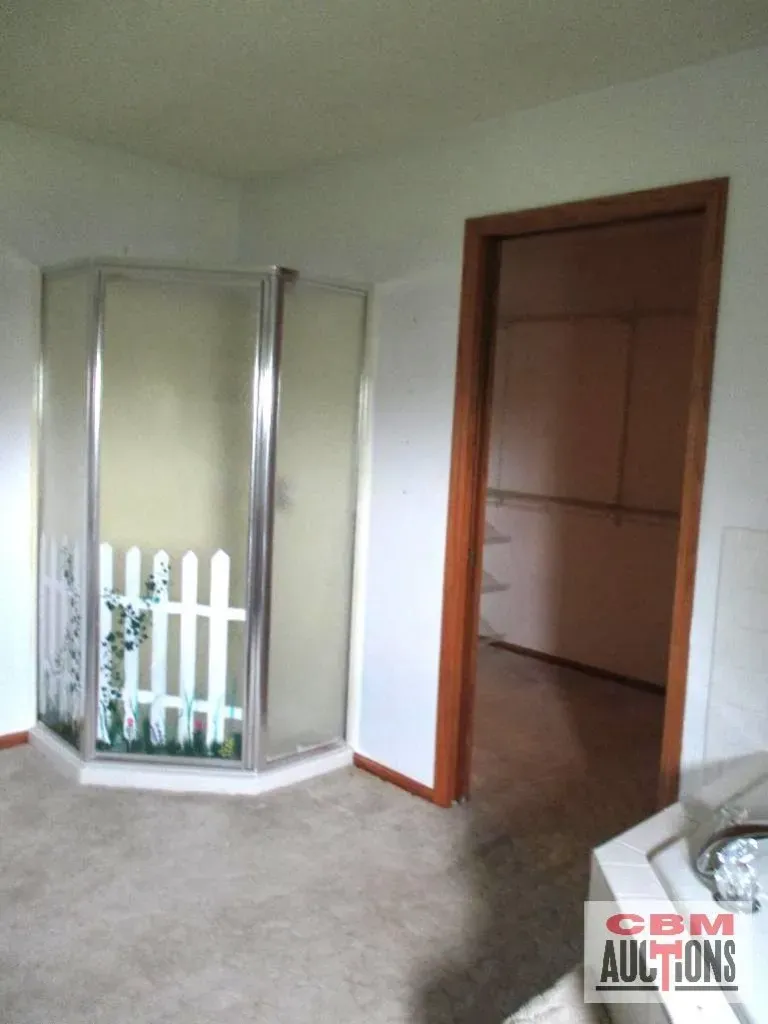 A bathroom with a walk in shower and a door that says gsm auctions