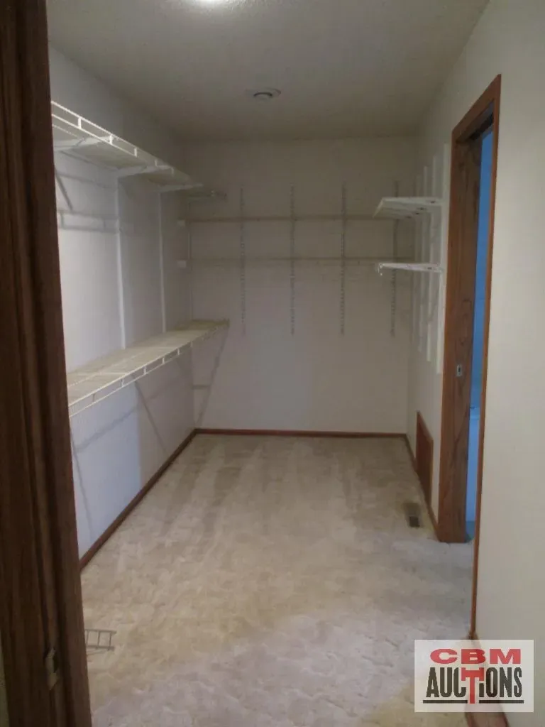 An empty walk in closet with a sign that says obm auctions