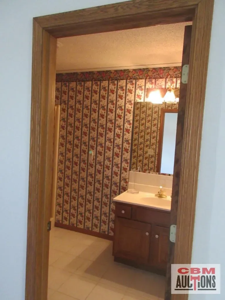 A bathroom with a cbm auction sign on the door