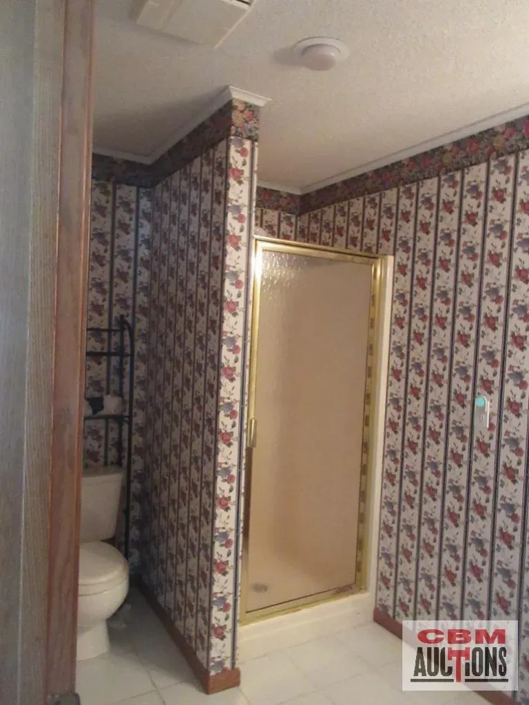A bathroom with a toilet and a shower.