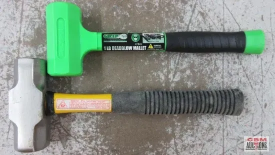 Two hammers with green handles on a concrete surface