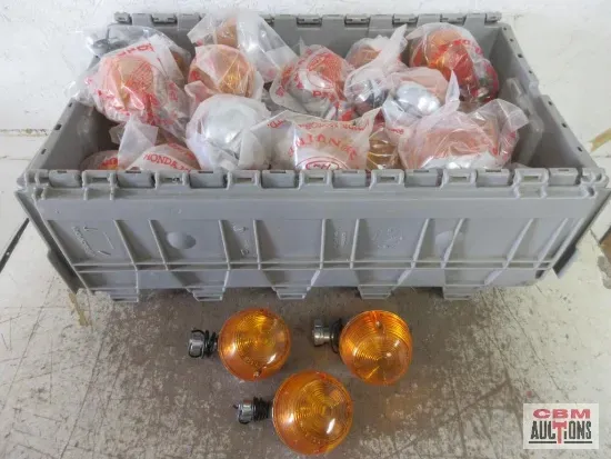 Gray bin filled with sealed orange lights. Three lights and hardware sit in front.