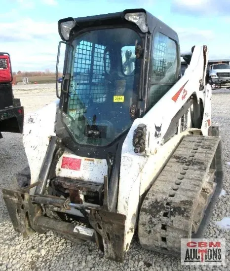 A bobcat tractor is parked in a gravel lot
