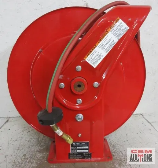 A red hose reel from cbm auctions sits on the floor