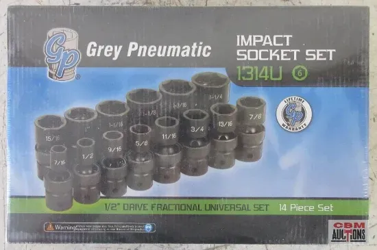 A white truck with a green bed is parked in front of a house