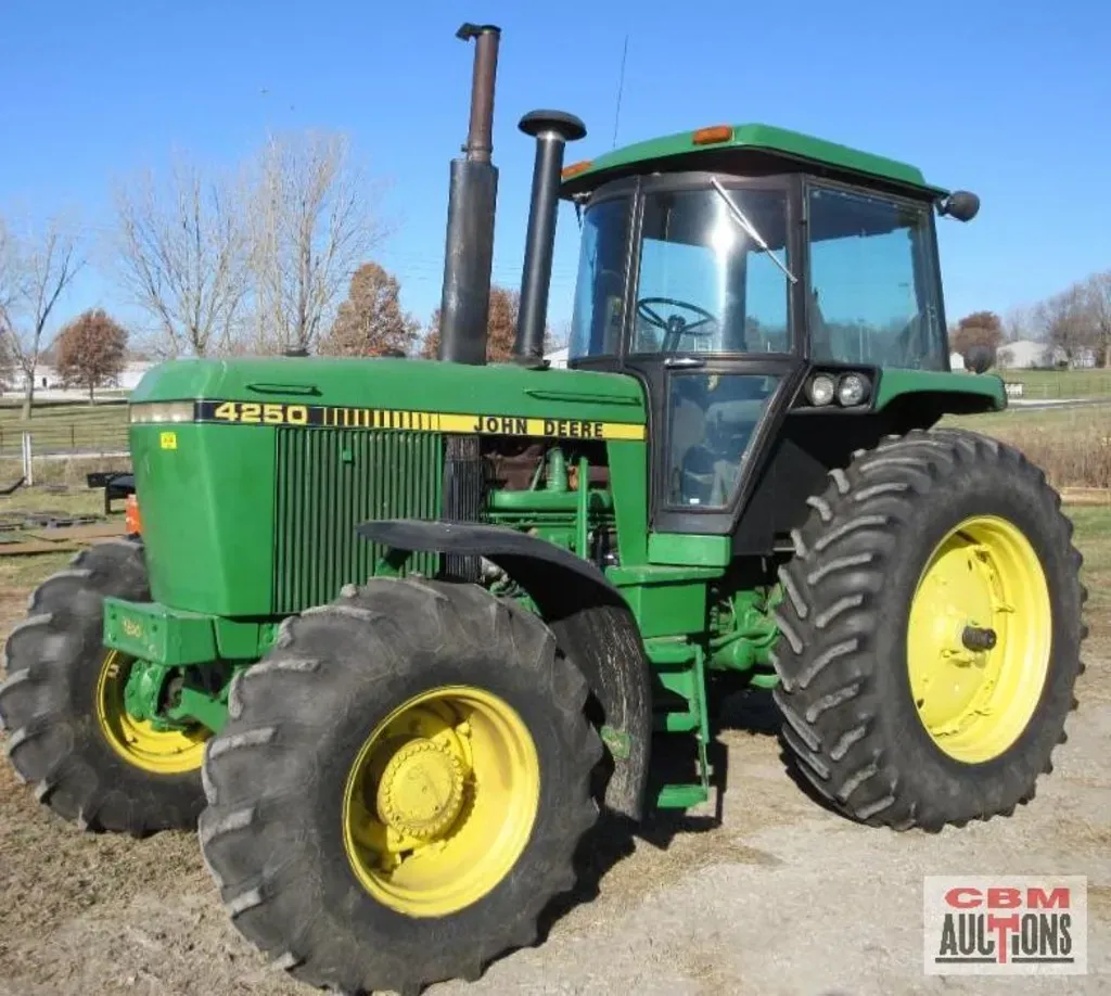 a green john deere 4250 tractor is parked in a field