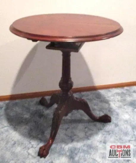 A small round table with a claw foot base is being sold by cbm auctions