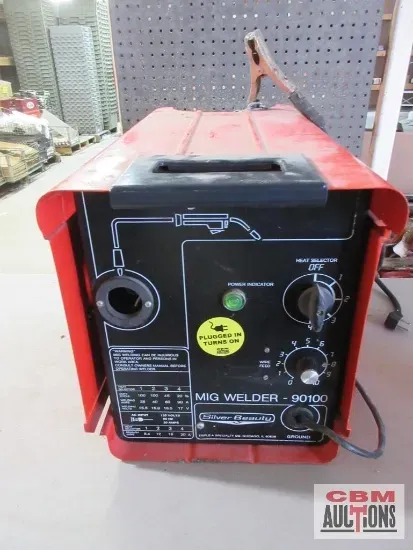 Hand axe with wooden handle and leather sheath on a textured surface.