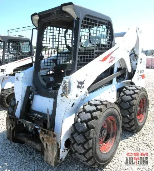 A bobcat skid steer is parked in a gravel lot