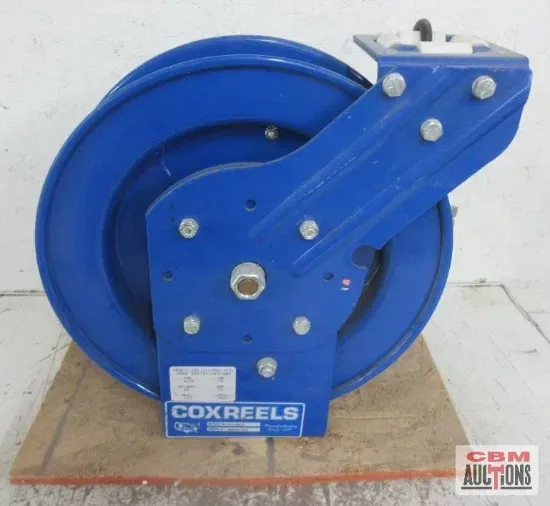 A blue cox reel is sitting on a wooden table