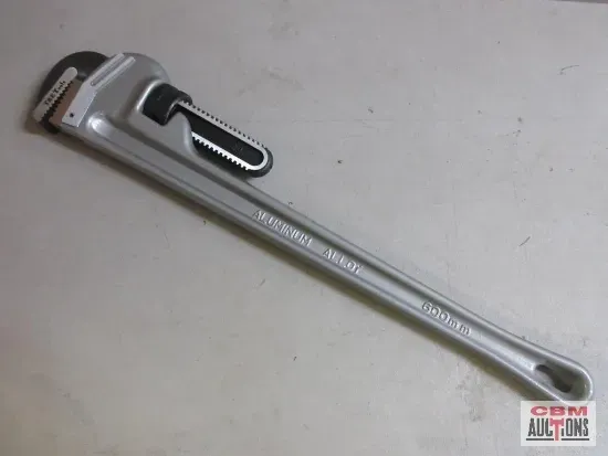 A pipe wrench is sitting on a white surface.