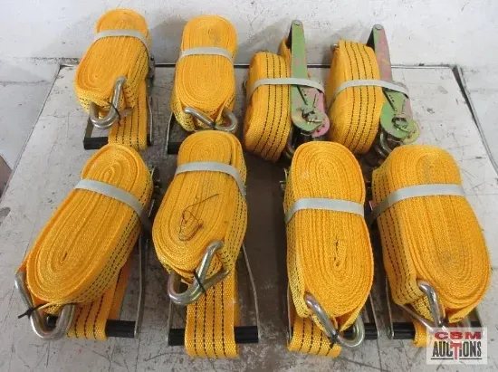 A bunch of yellow tie down straps are sitting on a table