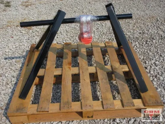 Black frame holding a plastic cup with red liquid on a wooden pallet outdoors.