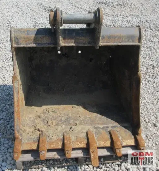 Excavator bucket with teeth, gray metal, filled with dirt, sitting on a pallet.
