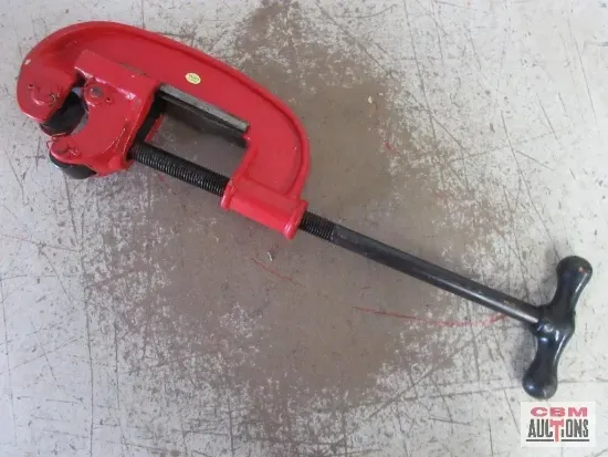 Red pipe cutter tool on a gray surface.