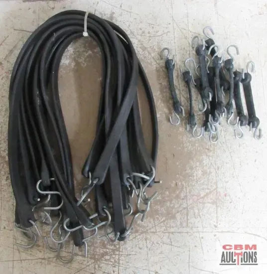Black rubber bungee cords with metal hooks; on a light surface.