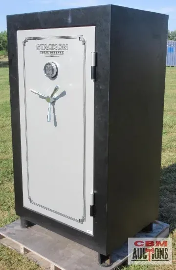 A large safe is sitting on top of a pallet in a field.