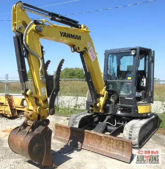 A yellow yanmar excavator is parked in a dirt lot