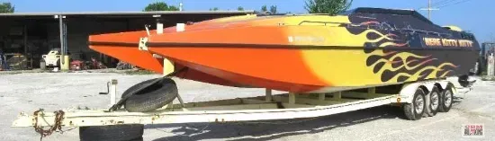 An orange and yellow boat is on a trailer.