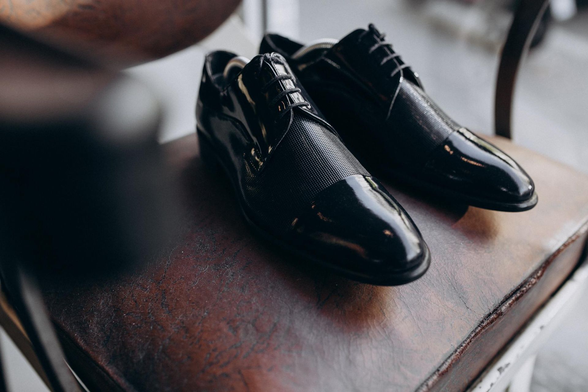 A pair of black shoes are sitting on a chair.