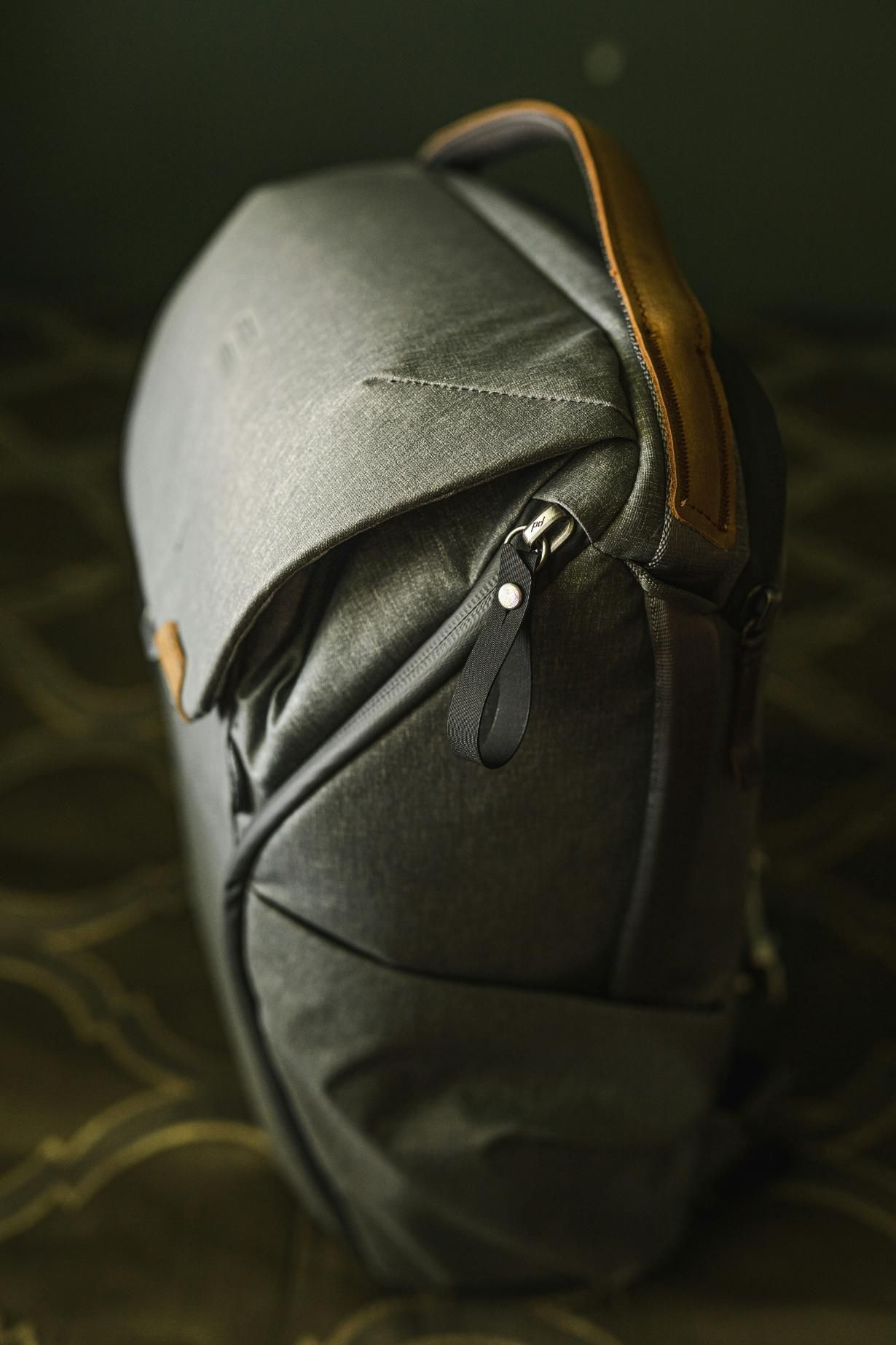 A black bag with a brown handle is sitting on a table.