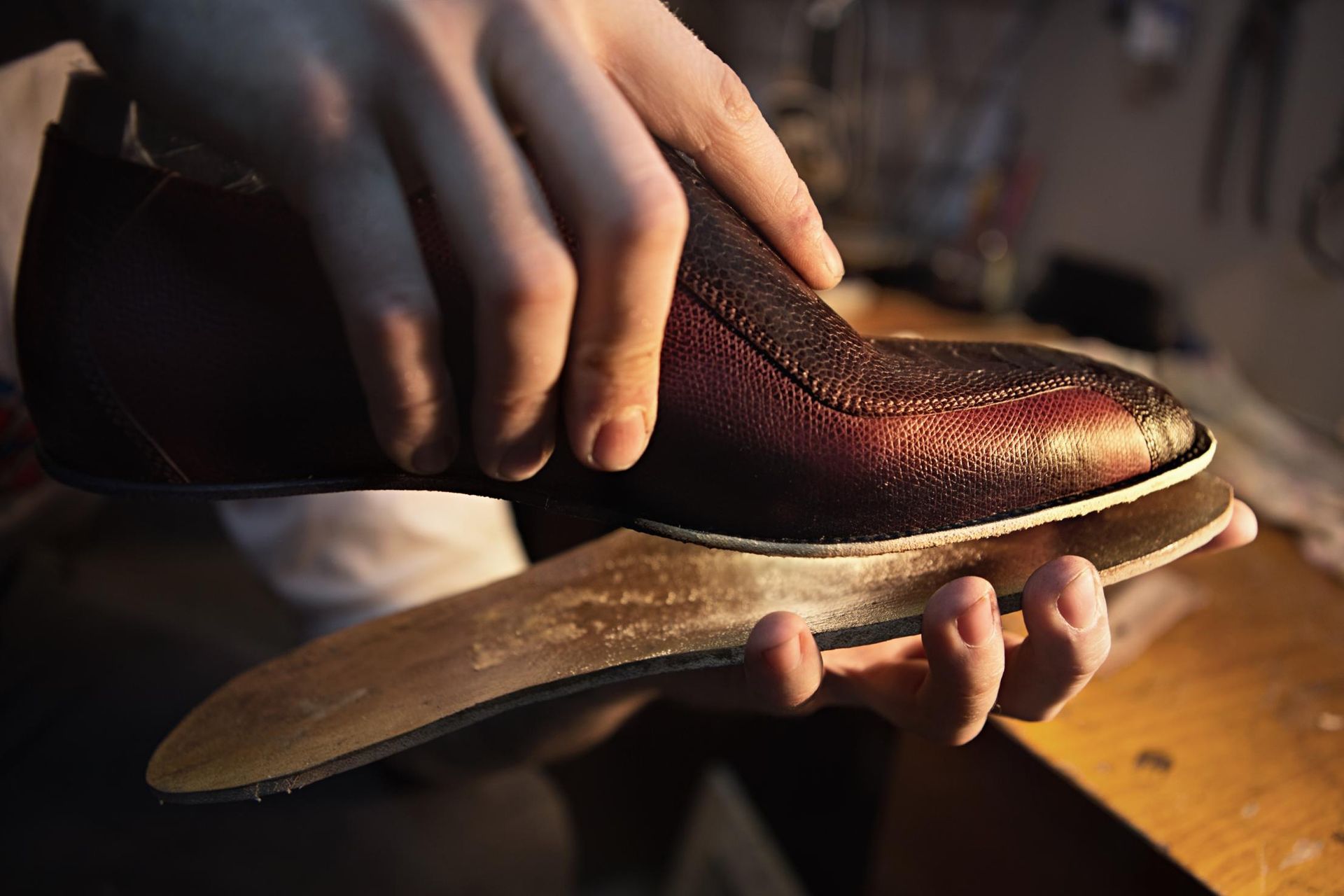 A person is holding a pair of shoes in their hands.