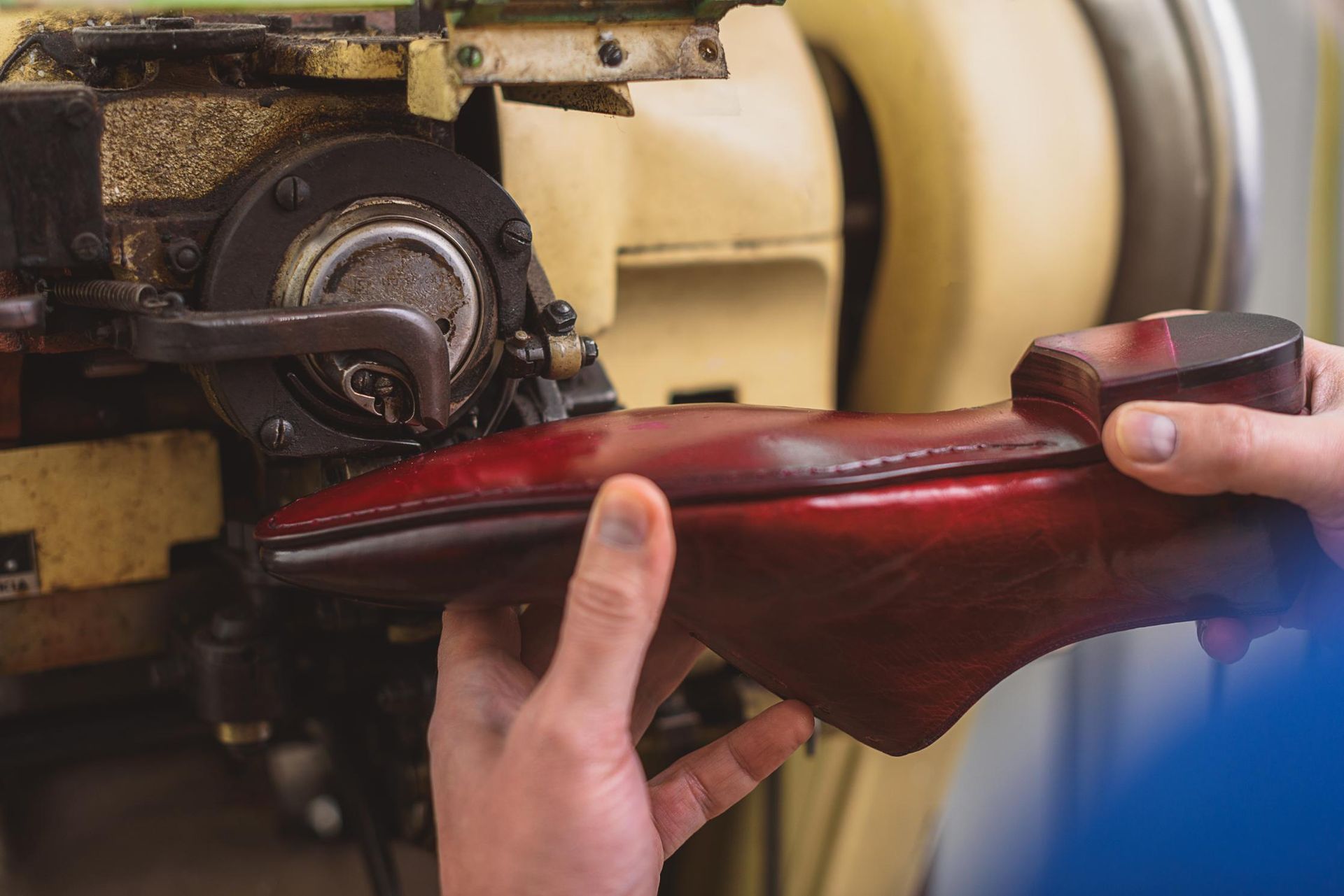 A person is holding a red shoe in front of a machine.