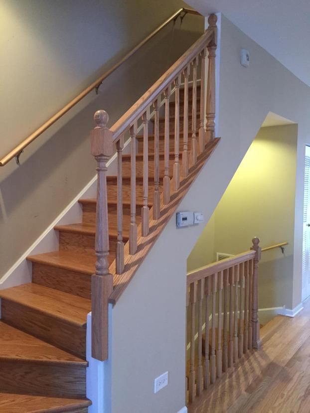 Wooden staircase with handrails, leading to upper floor, painted walls.