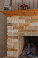 Brick fireplace with wooden mantel and decorative house.