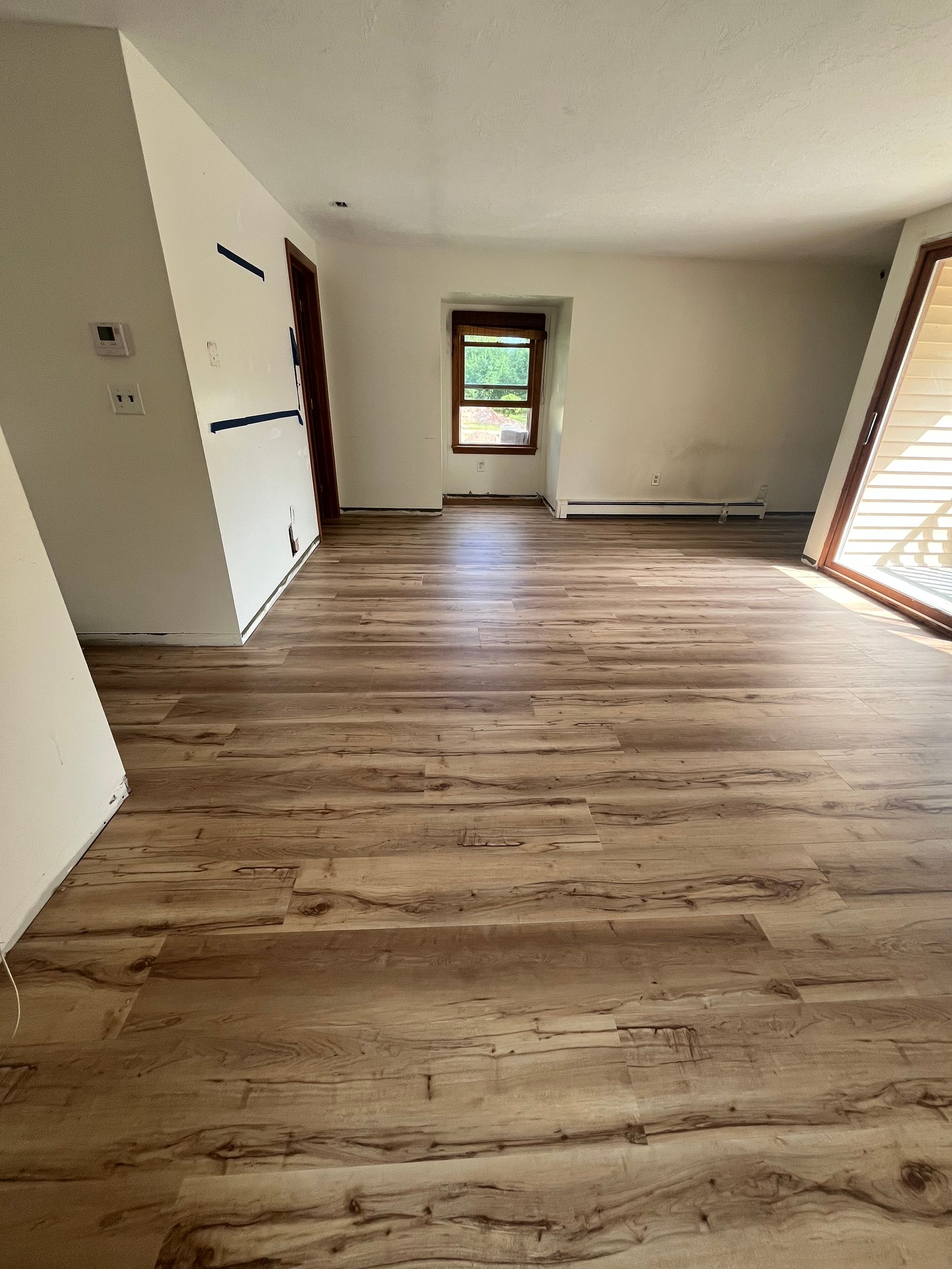 Freshly installed, gleaming hardwood floor in a well-lit room.