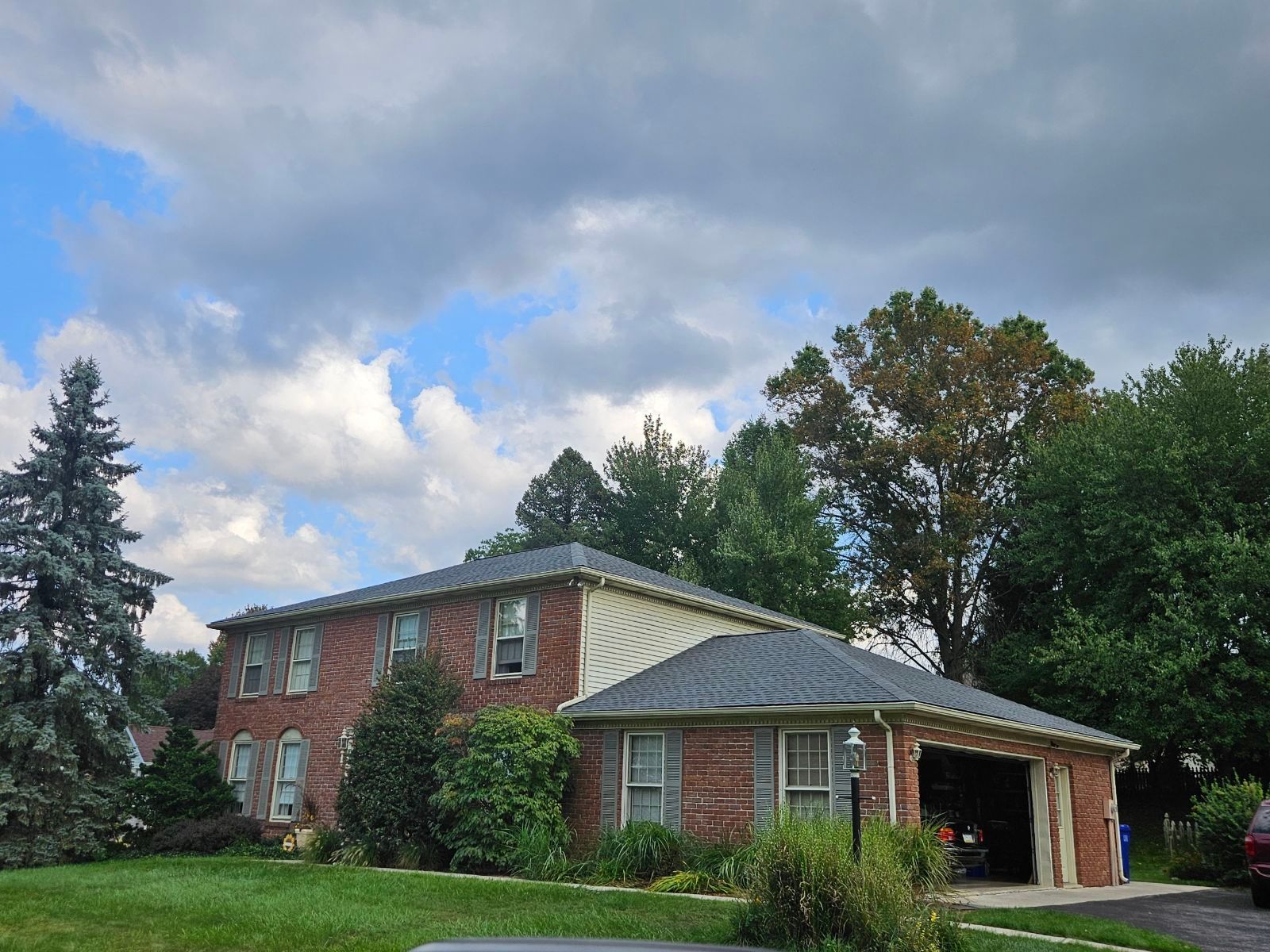 A brick house with a car parked in front of it