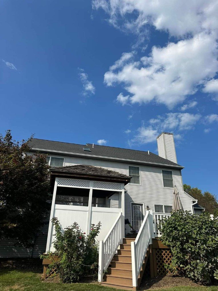 A gray house with white trim and a gray roof
