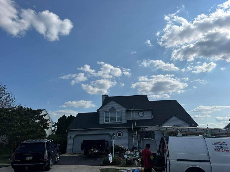 A man is standing in front of a house with a van parked in front of it.