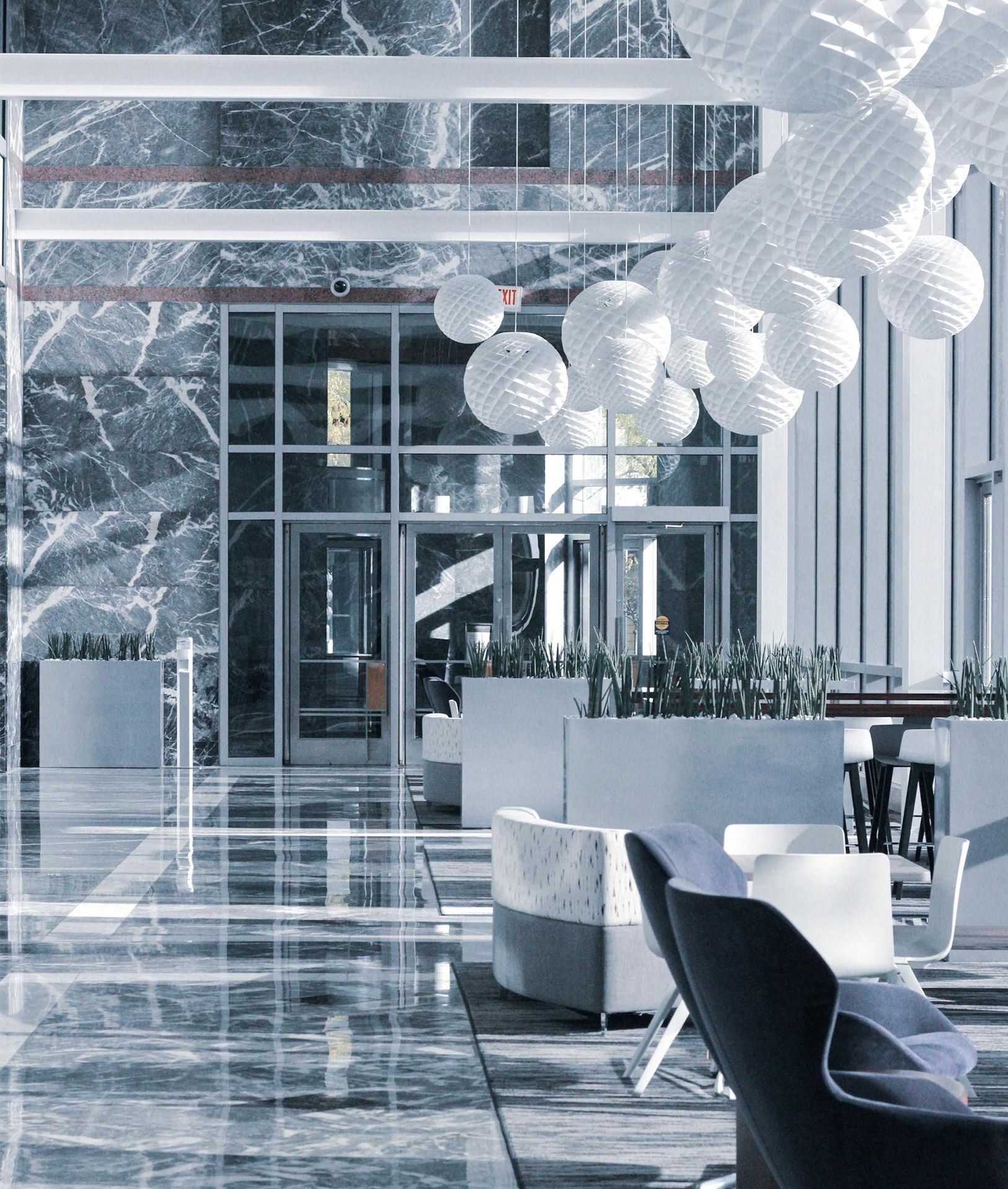 Modern lobby with marble floors and white globe lighting.
