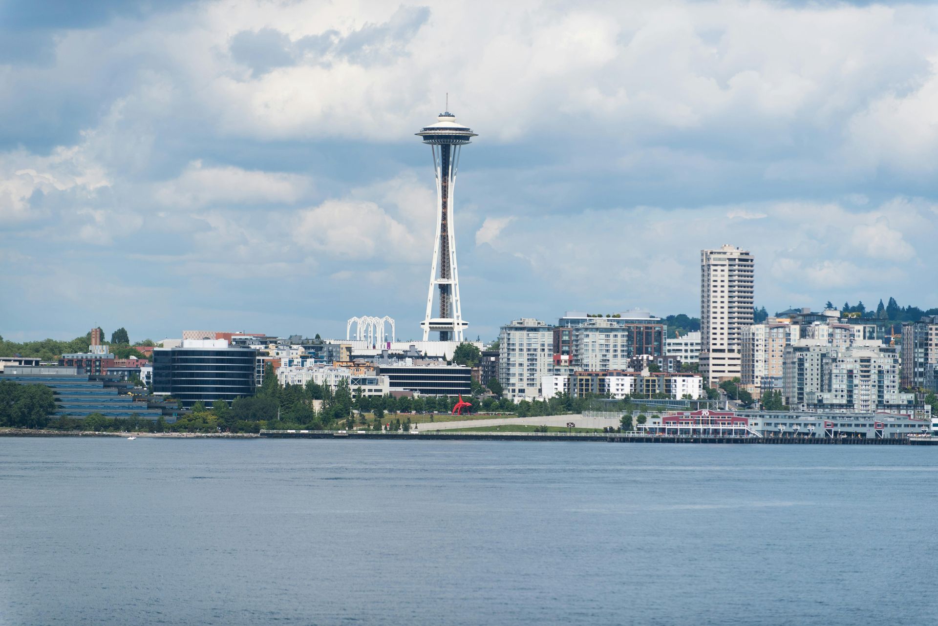 Seattle skyline with Space Needle, boat sailing on blue water.
