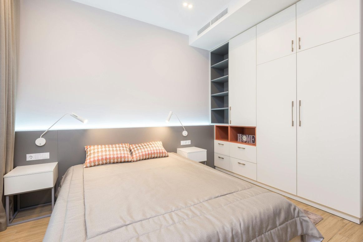 Bedroom with a bed, built-in closet, nightstands, and accent lighting.