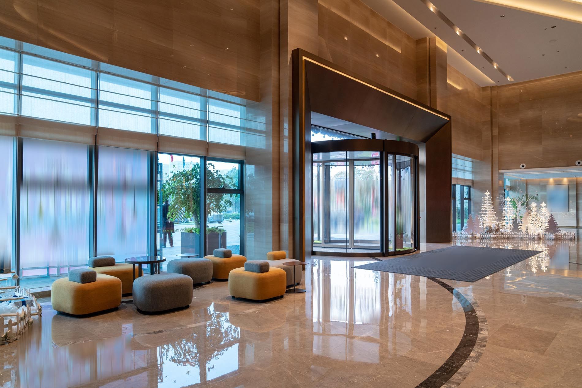 A large lobby of a hotel with a lot of windows and chairs.