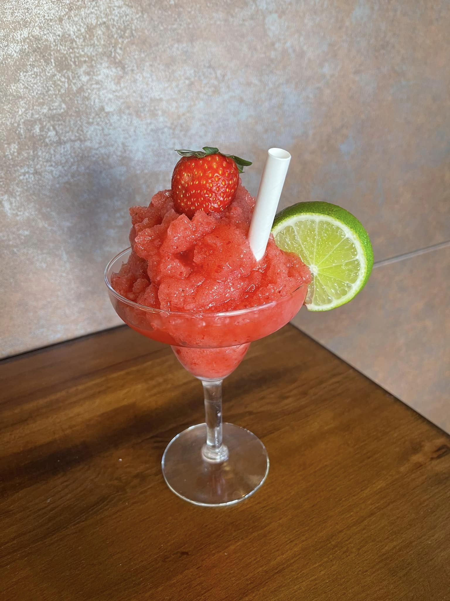 A Martini Glass Filled With Strawberry Ice Cream And Lime Slices — Original North Australian in Bowen, QLD