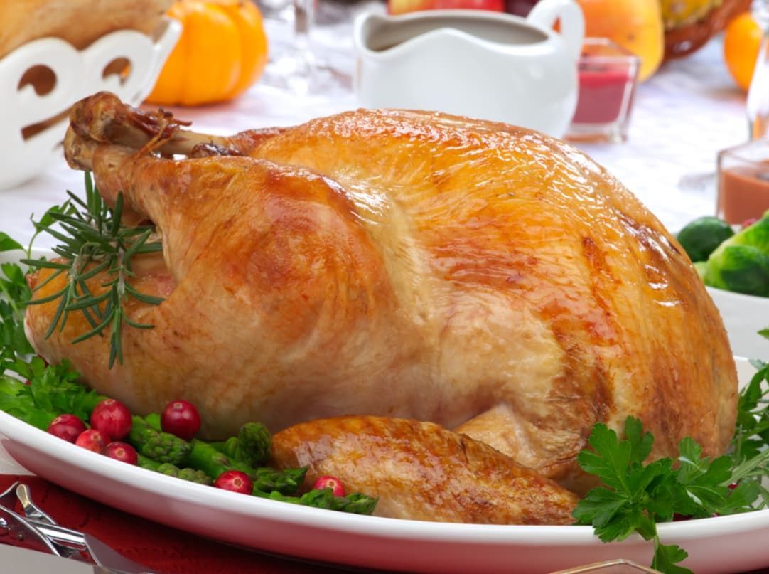 A Roasted Turkey Is Sitting On A White Plate On A Table — Original North Australian in Bowen, QLD