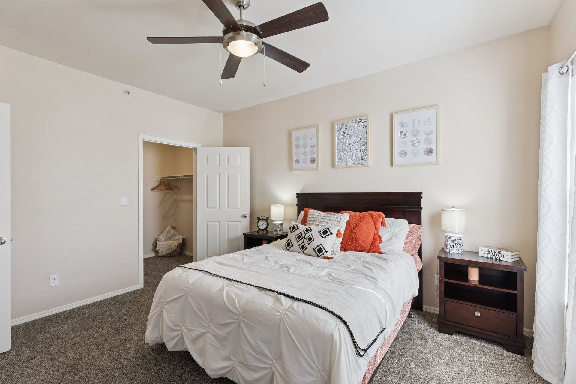Bedroom with bed, nightstands, closet, ceiling fan, and decorative artwork.