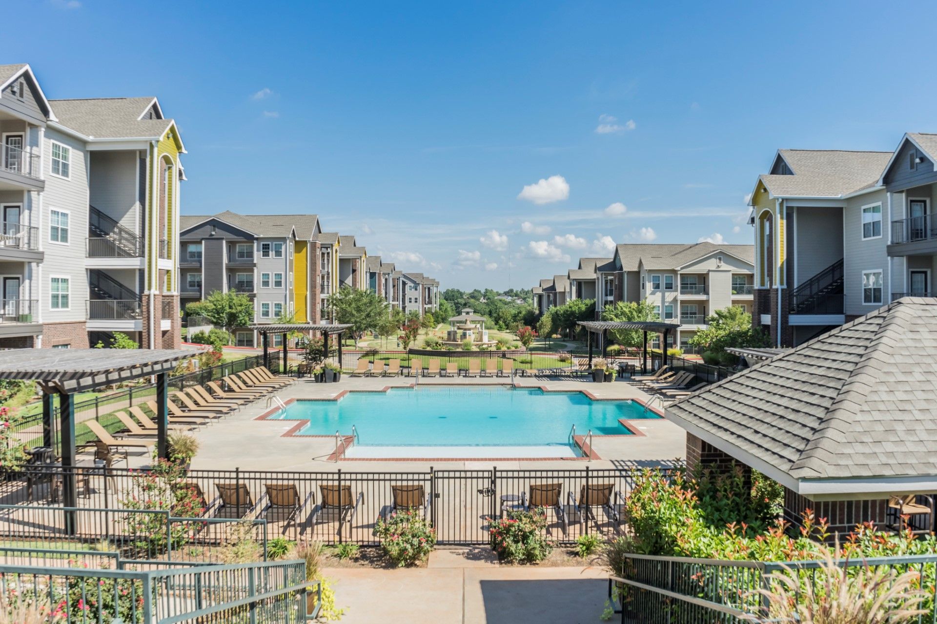 There is a large swimming pool in the middle of a large apartment complex.