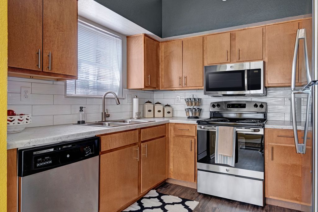 A kitchen with stainless steel appliances and wooden cabinets.