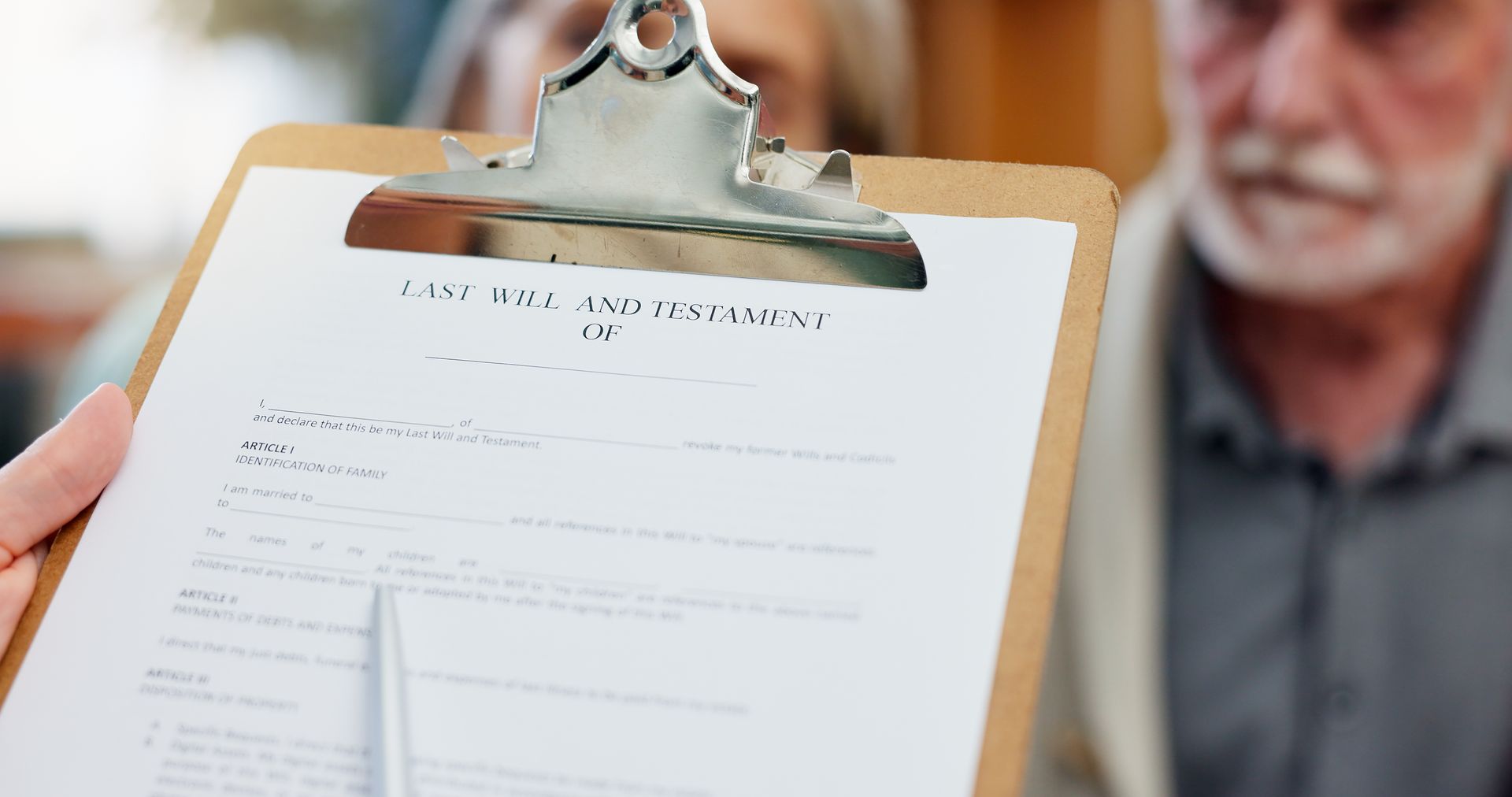 A person holding a clipboard with a document, facing a blurred senior man.